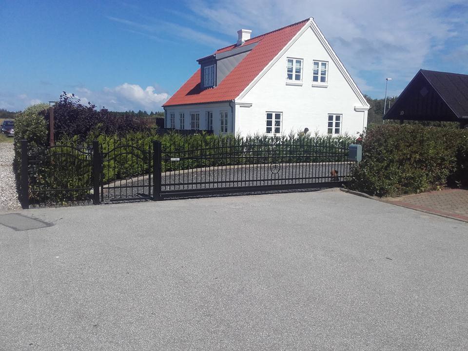 Hvid hus med nyt sort hegn foran.